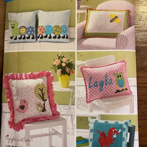 May include: A Simplicity sewing pattern for making five different pillow designs. The pillows feature a variety of designs, including a caterpillar, a bee, a bird, an owl, and a dragon. The pattern is for one size only.
