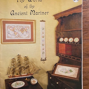 Puede incluir: Un folleto de punto de cruz vintage titulado "The World of the Ancient Mariner" que presenta un barco, un mapa y un sampler con un diseño floral. El folleto es un diseño original de Studio M.
