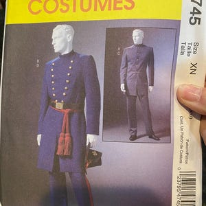 May include: A McCall's Costumes sewing pattern featuring a military-style uniform. The pattern shows a blue coat with gold buttons, a red sash, and matching trousers. The package includes the size XN.