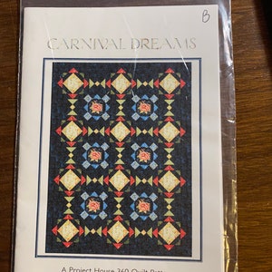 May include: A quilting pattern titled "Carnival Dreams" featuring a colourful quilt design with a repeating pattern of squares and triangles. The quilt is made up of red, yellow, blue, green, and white fabrics. The pattern is labelled as a "Project House 360 Quilt Pattern".