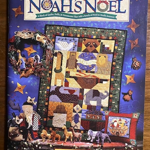 Può includere: Una copertina di libro con una trapunta colorata a tema Arca di Noè. Il titolo del libro è "Noah's Noel" e l'autrice è Debbie Mumm. La copertina del libro presenta anche una varietà di ornamenti e bambole fatte a mano.