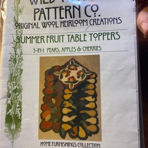 May include: A pattern for a wool rug featuring a 3-in-1 design of pears, apples, and cherries. The pattern is titled "Summer Fruit Table Toppers" and is from Wild Thymes Pattern Co. The pattern is #401 and is part of the Home Furnishings Collection.