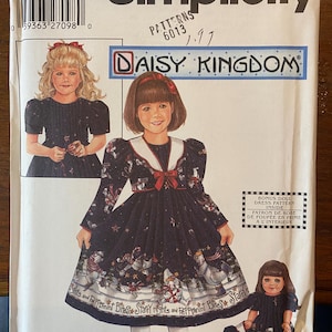 May include: Simplicity sewing pattern for a Daisy Kingdom dress, size BB 5, 6, 7, and 8. The pattern features a girl's dress with a white collar, red bow, and a print of snowmen and stars. Includes a bonus doll dress pattern.