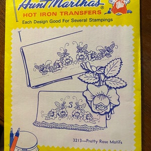 May include: A yellow package with a blue and white image of a floral design. The package is labeled "Aunt Martha's Hot Iron Transfers" and "3213-Pretty Rose Motifs". The package is for embroidery, textile painting, needlepoint canvas and other art crafts.