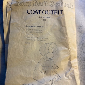 May include: A sewing pattern for a coat outfit for a baby doll. The pattern includes instructions for a coat and bonnet. The pattern is for a doll that is 44-45 inches tall. The pattern is from Fisher-Price.