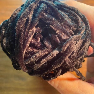 May include: A ball of black yarn with a fuzzy texture.