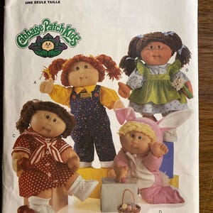 May include: A Butterick 5902 sewing pattern envelope for Cabbage Patch Kids dolls. The cover features four dolls wearing different outfits: blue overalls, a green dress, a red polka-dot dress, and a pink bunny costume with long ears.