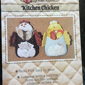 May include: A sewing pattern for a kitchen chicken utensil holder. The pattern includes two chickens, one with a red and black print and the other with a yellow print. The pattern is titled "Kitchen Chicken" and is from Patch Press. The pattern includes instructions for sewing the chicken utensil holder.