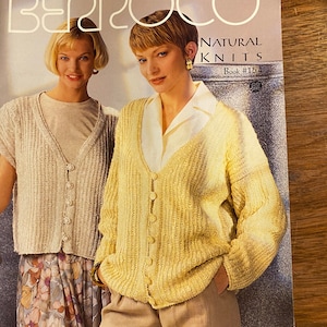 May include: Two women wearing knitted cardigans. The woman on the left is wearing a light beige cardigan and a floral skirt. The woman on the right is wearing a yellow cardigan and khaki pants. The text on the page reads "Berroco Natural Knits Book #154".