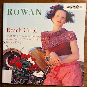 May include: A magazine cover featuring a woman wearing a crocheted top and pink shorts. The cover is titled "Rowan Beach Cool" and features the text "Over Sixteen designs featuring Linen Print & Cotton Braid by Lois Daykin".