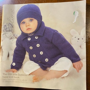 Puede incluir: Un jersey de punto morado para bebé con botones y un gorro a juego. El jersey tiene un diseño de doble botonadura y el gorro tiene una solapa abatible. El quinto pequeño libro de punto Sublime. Baby cashmere merino silk dk. 25 diseños para bebés de 0 a 3 años.