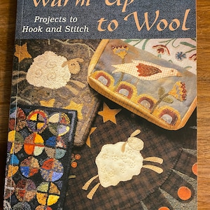 May include: Book cover with the title "Warm Up to Wool" and the subtitle "Projects to Hook and Stitch". The cover features a patchwork design with a white sheep, a bird, and a star.