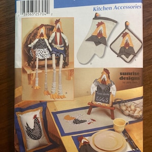 May include: A Simplicity 7166 sewing pattern envelope for home decorating kitchen accessories. The cover features illustrations of fabric chicken-themed dolls, an oven mitt, a potholder, a small sign, a pillow, and a placemat set.