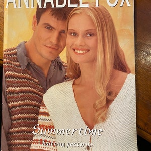 May include: A book cover featuring a couple wearing knitted sweaters. The book title is "Summertime Knitting Patterns" by Annabel Fox.