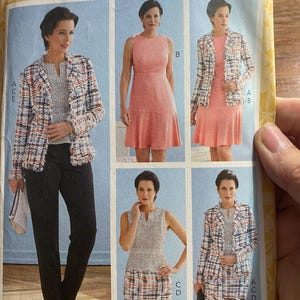 May include: A Butterick sewing pattern featuring a woman modeling various outfits. The outfits include a pink dress, a tweed jacket, a skirt, and pants. The pattern number B6738 is visible at the top.