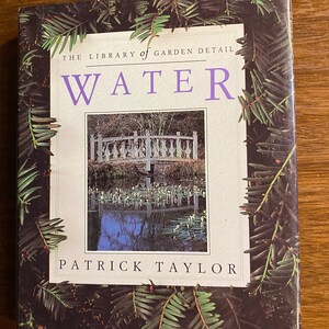 May include: A book titled "Water" from "The Library of Garden Detail" series by Patrick Taylor. The cover features a photograph of a garden scene with a white bridge over a pond, framed by green foliage.