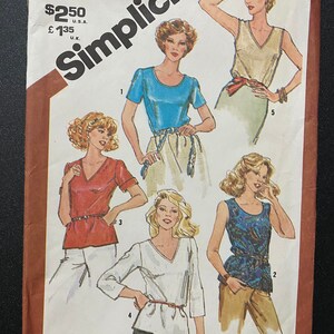 May include: Simplicity sewing pattern number 5380 for a women's blouse. The pattern includes five different styles of blouses with short sleeves, long sleeves, and sleeveless options. The pattern is for sizes 14.