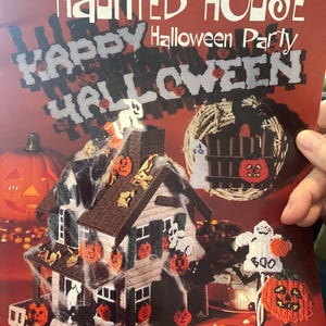 May include: A plastic canvas pattern for a Halloween-themed haunted house. The cover features a finished needlework project with a spooky house, pumpkins, ghosts, and the words "Happy Halloween". The pattern is by Don FranzMeier.