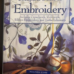 May include: The Reader's Digest Complete Book of Embroidery by Melinda Coss features a cover with floral embroidery patterns in blue and green. The text includes the subtitle Includes Crewelwork, Goldwork, Ribbon Embroidery, and Embellishments.