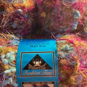 May include: A skein of Phentex Fashion Two yarn in a multi-colored mix of blue, pink, and gold. The yarn is 100% nylon and weighs 1.75 ounces. The label says "Free Pattern on Label".