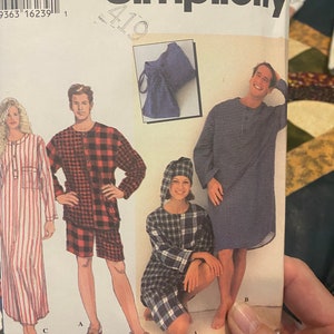 May include: Simplicity sewing pattern for pajamas, featuring three different styles. The pattern includes a long-sleeved shirt with a plaid design, a pair of shorts with a plaid design, and a long-sleeved nightgown with a plaid design. The pattern is for sizes BB, L, and XL.