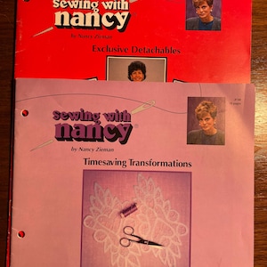 Puede incluir: Dos libros de costura con el título "Sewing with Nancy" en las portadas. El libro superior es rojo y dice "Exclusive Detachables" y el libro inferior es rosa y dice "Timesaving Transformations".