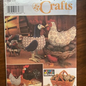 May include: A Simplicity Crafts sewing pattern envelope, number 5737, featuring illustrations of fabric chickens and roosters. The package displays various stuffed poultry designs, including a large rooster, a hen in a nest, and small chicks.