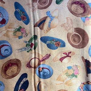 Może przedstawiać: Wzór tkaniny przedstawiający kapelusze w stylu vintage w odcieniach brązu, błękitu, zieleni i beżu. Kapelusze zdobione są wstążkami, koronkami i kwiatowymi ozdobami. Całość ma klasyczną, kobiecą estetykę.