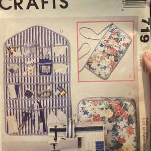 May include: A McCall's Crafts sewing pattern featuring a sewing machine, a striped organizer, and floral fabric accessories. The pattern includes instructions for a sewing machine cover and a multi-pocket organizer.