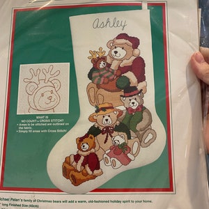 May include: A cross stitch pattern featuring a family of Christmas bears with a reindeer. The pattern is titled "Bear Collection" and includes the name "Ashley". The pattern is 16 inches (40 cm) long.
