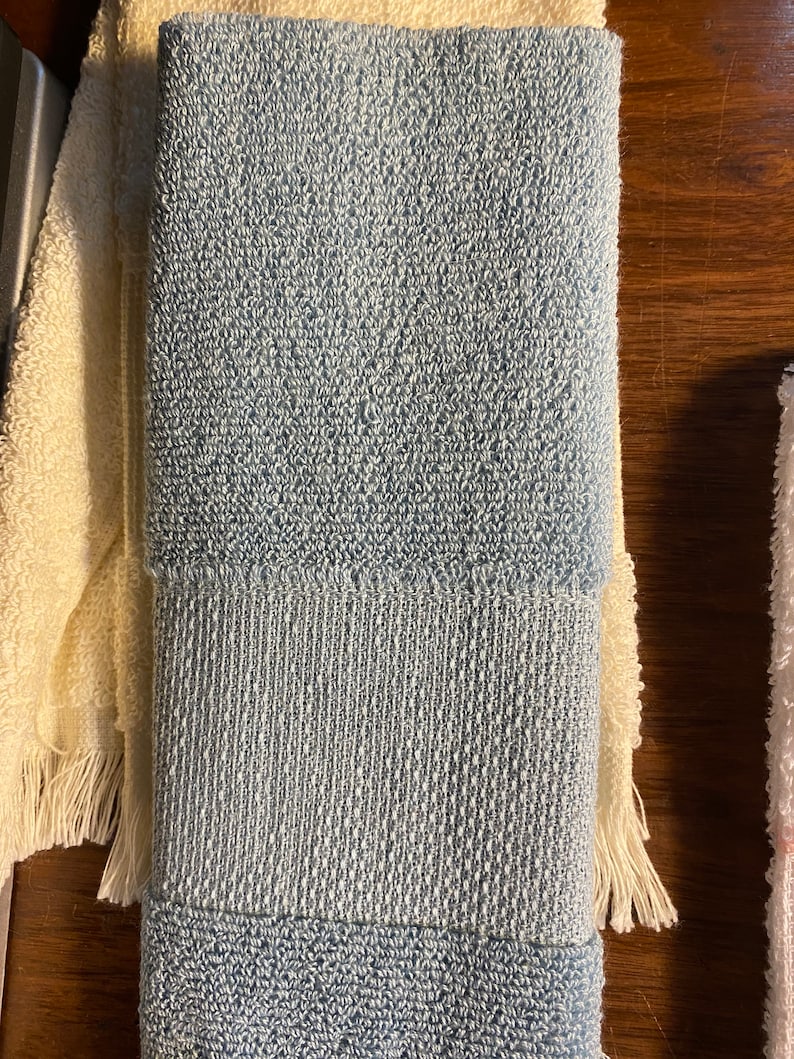 May include: A folded blue and white striped towel with a textured surface.