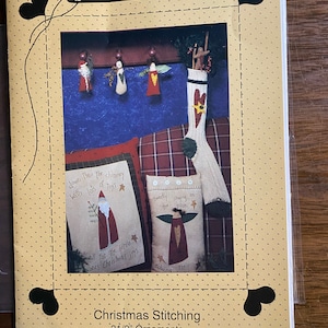 May include: A craft pattern for Christmas stitching, featuring a stocking, two pillows, and three ornaments. The pattern includes the text "down the chimney with lots of toys" and "all for the little ones Christmas joys".
