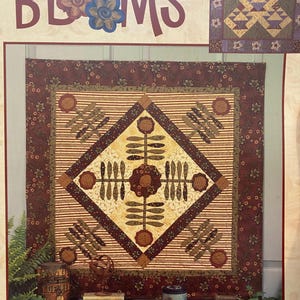 Puede incluir: Un libro de patrones de acolchado titulado "Vintage Blooms" que presenta una colcha con una combinación de colores marrón, crema y verde. La colcha está compuesta por una variedad de bloques, incluyendo un bloque central con un diseño floral. El libro también incluye instrucciones para hacer una bolsa de mano.