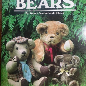 May include: The cover of a book titled "MAKING BEARS" by Nancy Southerland-Holmes. It shows three handmade teddy bears in different colours and sizes, set against a backdrop of green foliage. The bears are wearing different outfits.