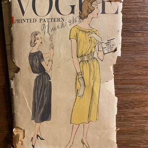 May include: Vintage Vogue printed pattern featuring illustrations of two dresses. The pattern cover is torn and aged, with the Vogue logo and text visible. The illustrations depict a yellow and a black dress, showcasing classic 1950s fashion.