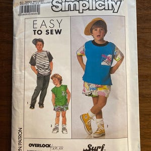 Può includere: Modello di cucito Simplicity 9182, taglia A, con illustrazioni di abbigliamento per bambini. Il modello include disegni per t-shirt, pantaloncini e camicia. Il testo "Easy to Sew" è ben visibile.