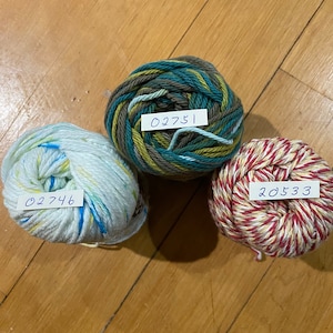 May include: Three balls of yarn in different colors and patterns. The yarn is labeled with the numbers 02746, 02751, and 20533.