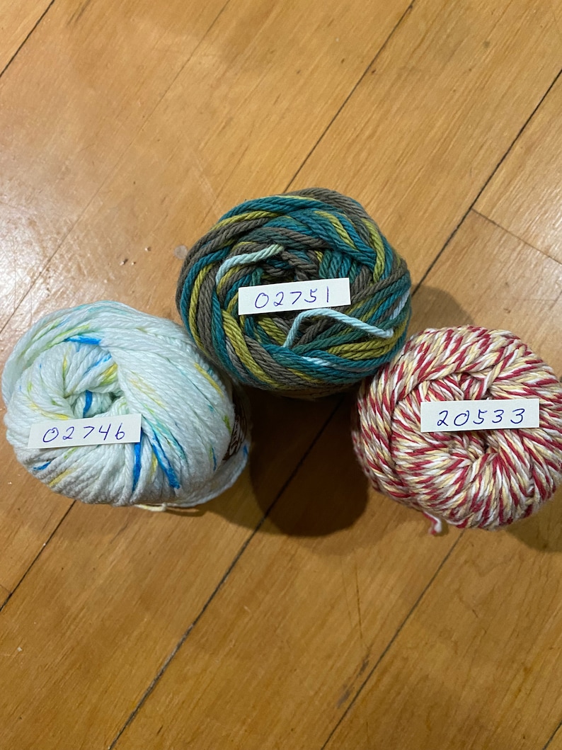 May include: Three balls of yarn in different colors and patterns. The yarn is labeled with the numbers 02746, 02751, and 20533.