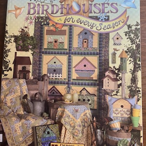 May include: A book cover titled "DEBBIE MUMM'S BIRDHOUES for every Season" features a patchwork design of birdhouses in various colors. Decorative elements include birds, flowers, and a price tag.