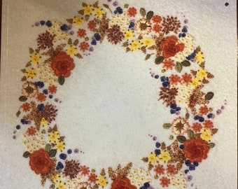 May include: Book cover with the title "An Introduction to Wool Embroidery" and the author's name "Carol Hubert". The cover features a wreath of embroidered flowers in shades of red, yellow, and brown.