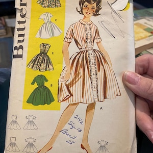 May include: Vintage Butterick sewing pattern featuring a dress illustration with vertical stripes and a button-down design. The pattern includes multiple dress styles and sizing information. The text on the pattern reads "2192 Size 10 Breast 28".