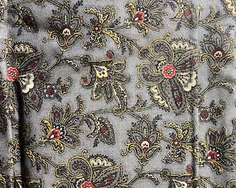 May include: Close-up of a fabric with a gray background and a repeating floral paisley pattern. The design features large, stylized flowers in shades of gray, burgundy, yellow, and cream. The fabric has a textured appearance.