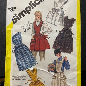 Könnte beinhalten: Ein Schnittmuster für ein Kleid mit einer Schürzen-Überlage. Das Schnittmuster enthält Anweisungen, wie man mit Karos arbeitet. Das Schnittmuster ist für die Größen 14-16 und stammt von Simplicity Schnittmuster Nummer 6173.