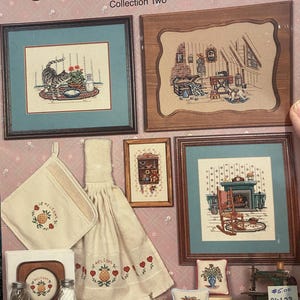 Puede incluir: Una colección de patrones de punto de cruz y accesorios de cocina. La imagen presenta muestras de punto de cruz enmarcadas, un agarrador, una toalla y un posavasos, todos con un diseño de piña acogedor. El texto "Times Remembered" y "Collection Two" son visibles.
