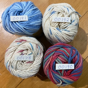 May include: Four balls of yarn in different colors and patterns. The yarn is labeled with the numbers 00181, 00192, 00178, and 00190.