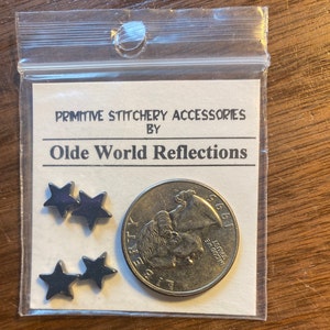 Puede incluir: Un paquete de cuatro estrellas de metal negro en forma de estrella para la costura primitiva. El paquete incluye una pequeña moneda para referencia de tamaño. El paquete está etiquetado "Primitive Stitchery Accessories by Olde World Reflections."