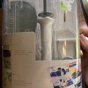 Puede incluir: Un paquete de plástico transparente que contiene una herramienta de soldadura de fundas para fotos. La herramienta tiene un mango blanco y una punta de metal. El paquete también incluye una regla e instrucciones. El texto en el paquete incluye "TOOL PHOTO SLEEVE WELDER".