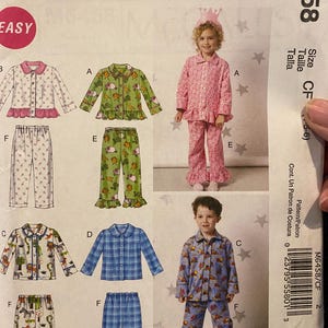 May include: McCall's sewing pattern for children's pajamas. The pattern features various pajama styles, including floral, plaid, and patterned designs. The image shows children modeling the finished pajamas. The pattern number is M6458.