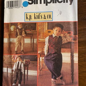 May include: Simplicity sewing pattern number 8567 for children's clothing. The pattern is for sizes AA (3-6) and features three boys wearing different outfits. The pattern is titled "k.p. kid's & co."