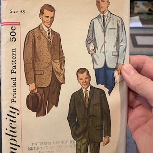 May include: A vintage Simplicity sewing pattern with illustrations of men's suit jackets. The pattern is labelled "3647" and "Size 38". The price is marked as 50c. The cover has a beige background with red and black text.